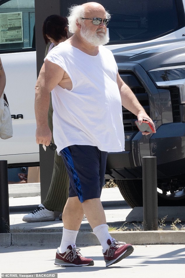 The single father was seen wearing a white sleeveless T-shirt, dark blue shorts, sunglasses and a summer hat as he walked briskly through the city.