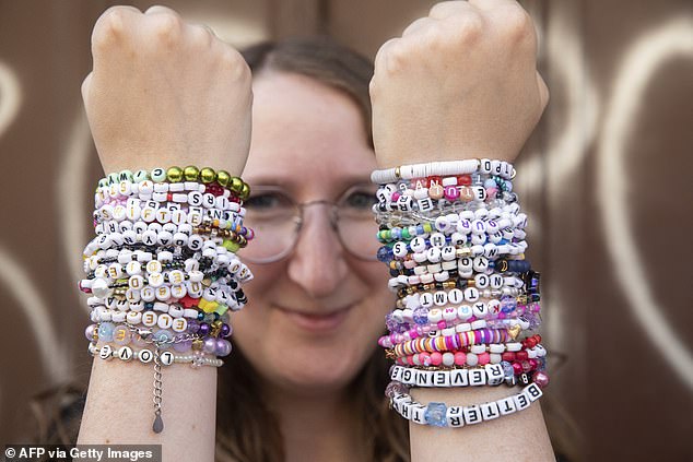 A fan of American singer Taylor Swift - a Swiftie - proudly shows off her many friendship bracelets