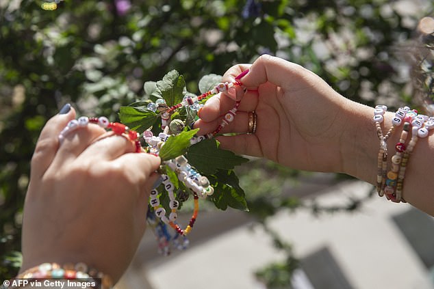 Fans of American singer Taylor Swift - swifties - repair their bead bracelets at the Swiftie Tree on Cornelius Strasse in Vienna