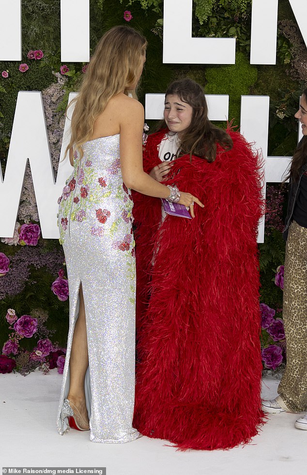 The Hollywood star, who wore glittering silver Louboutins, gave her plush red coat to a young fan