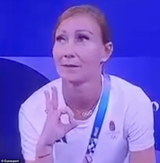 Hungarian rhythmic gymnastics coach Gelle made a hand gesture as she stood in front of the camera