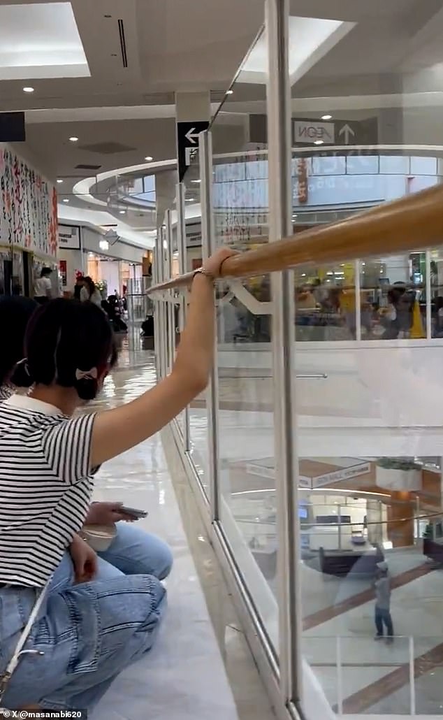 Others brace themselves in a shopping mall as the tremors disrupt their daily activities