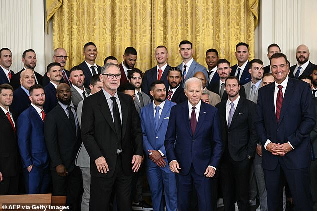 President Joe Biden poses for a photo with the World Series-winning Texas Rangers after telling the team he's a Philadelphia Phillies fan because of his wife