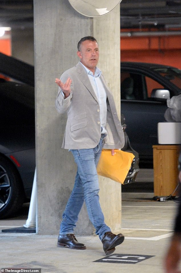 The Air actor-director wore a gray sports jacket over a light blue shirt with blue jeans and black boots.