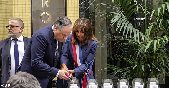 Second Lord Doug Emhoff, left, and Paris Mayor Anne Hidalgo light a candle during the 42nd anniversary of the attack on the Rue des Rosiers in the heart of Paris' Jewish quarter, Friday, Aug. 9, 2024. (AP Photo/Michel Euler)