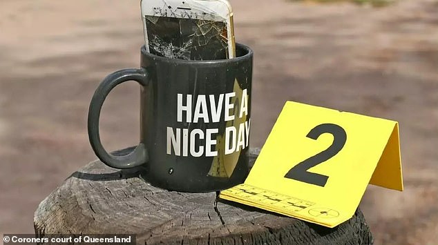 This 'Have a nice day'" coffee mug was glued to a gate post at the entrance to the building