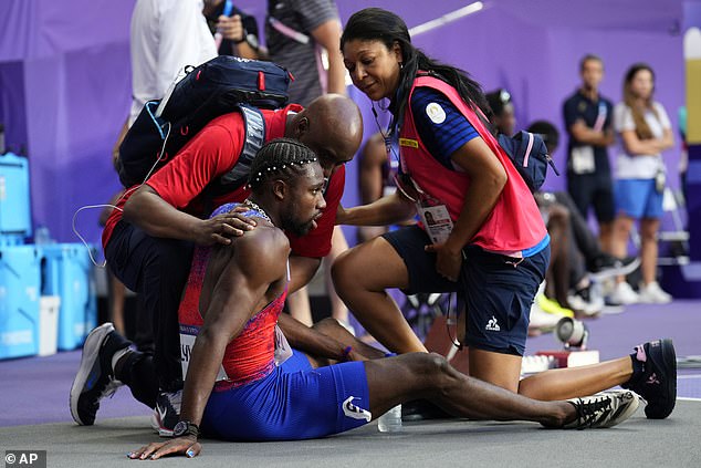 Team USA's Noah Lyles is treated by medical personnel after the men's 200 meters final