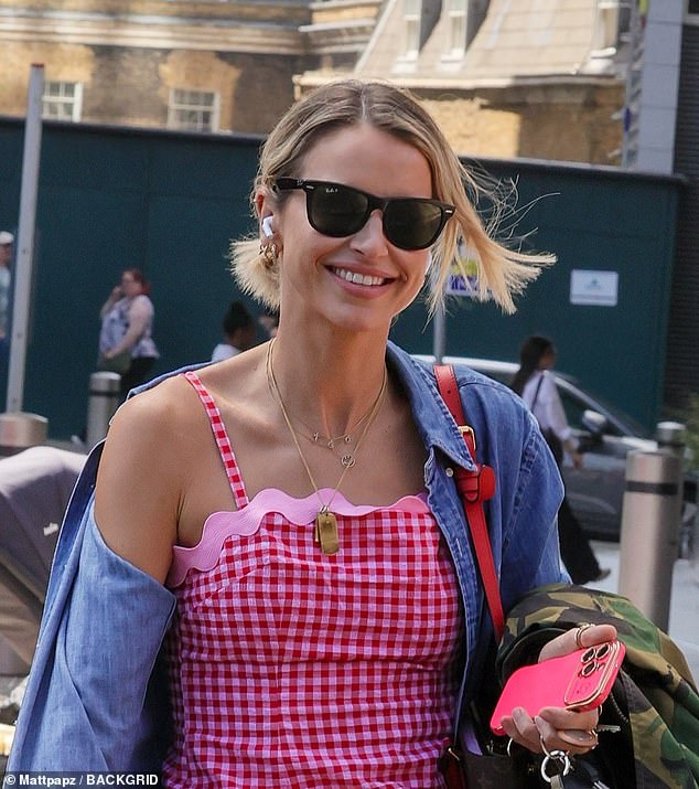 Vogue paired her thigh-length dress with a denim blouse and bold red sneakers, while she carried a camouflage jacket in her arms