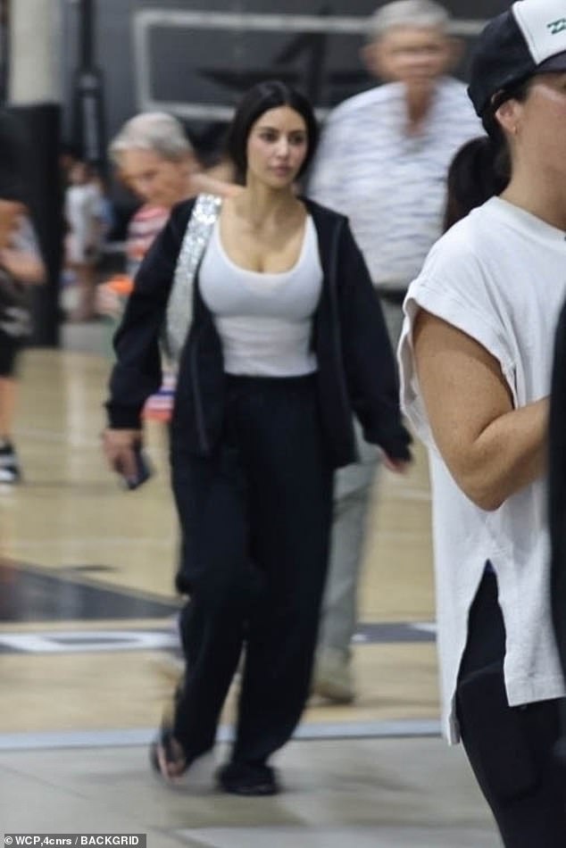 Kim wore baggy black sweatpants and an oversized black zip-up hoodie over a white tank top