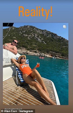 She held a glass of Aperol Spritz in a nod to her swimsuit and relaxed under a pair of black sunglasses as she placed one arm behind her head