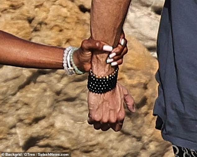 Naomi was seen holding Mohammed's wrist to steady herself on the slippery path