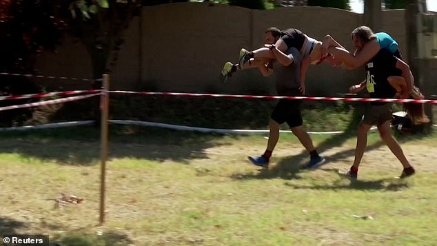 Couples race through water ditches in Hungarian wife-carrying contest