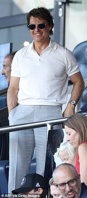 The Mission: Impossible star looked dapper for the outing at Parc des Princes as he wore a white polo shirt paired with tailored grey trousers