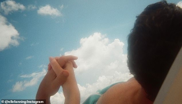 She added a photo she took of herself and Gus sunbathing on the beach holding hands