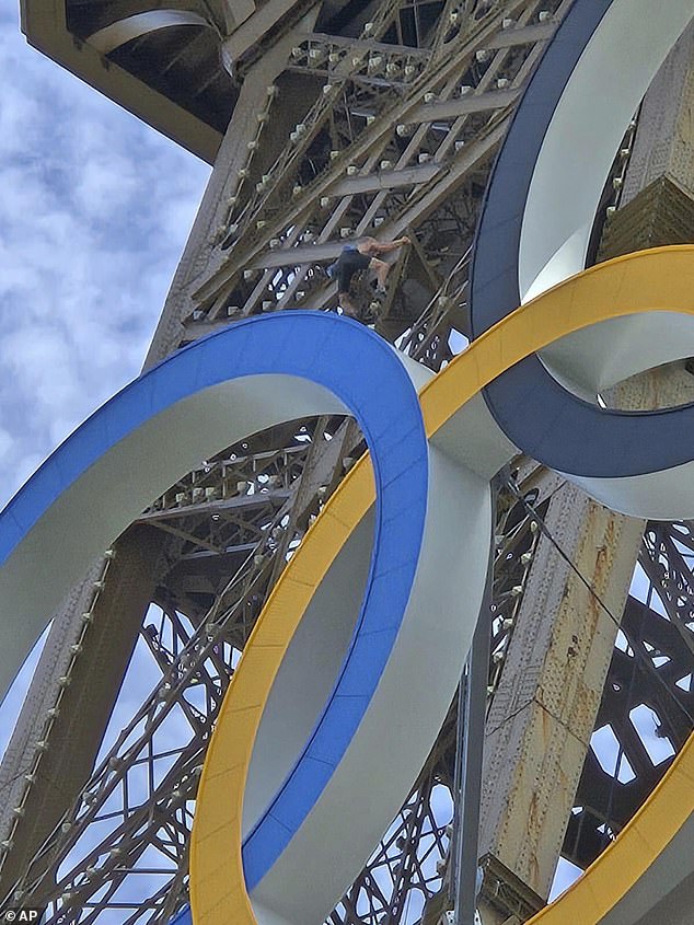 It was unclear where he began his climb, but he was spotted just above the Olympic rings that adorn the second part of the monument