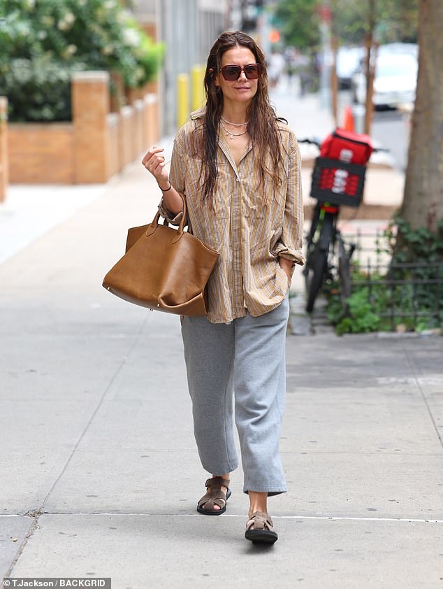 Her hair looked like she had washed it and just let it air dry. She wore several layers of necklaces and sunglasses and carried a large brown leather handbag.