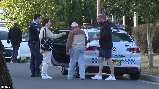 The man was escorted by officers to the back of a police car waiting outside the house