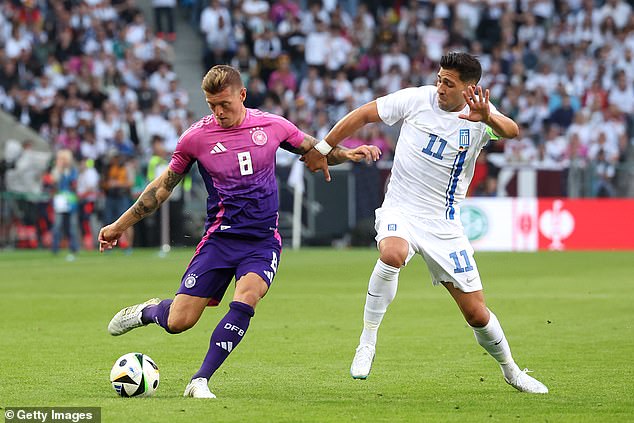 Ioannidis (right) pictured challenging Germany's Toni Kroos during his match for Greece in June