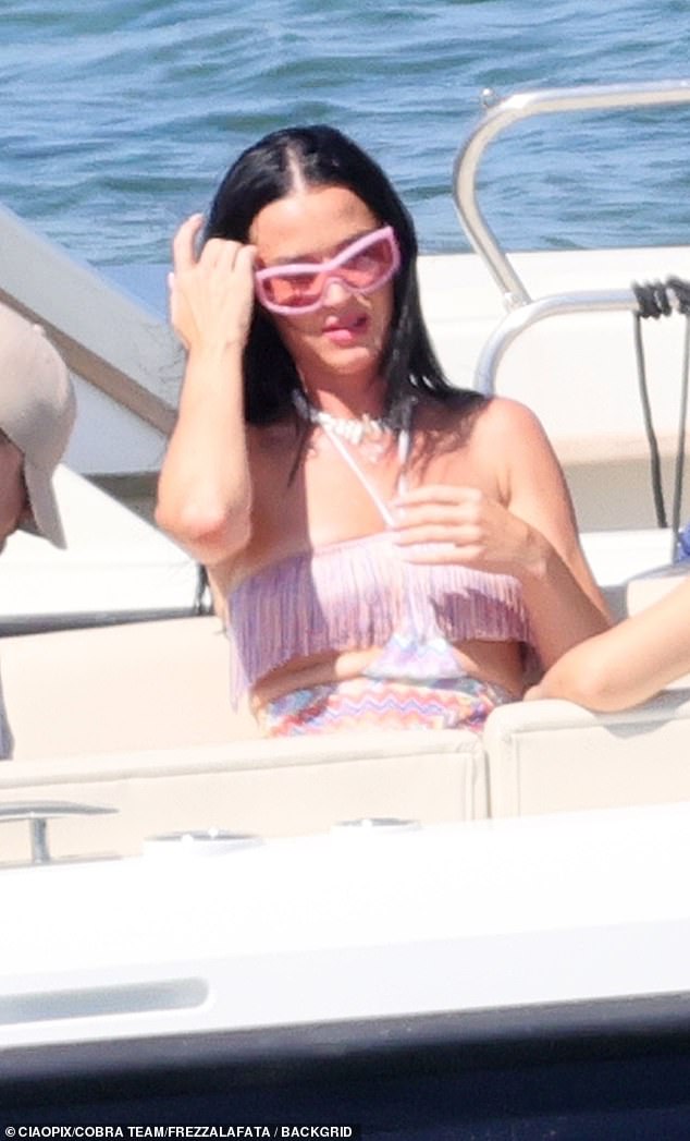 Perry, 39, showed off her toned figure in a rainbow-colored summer dress featuring a fringed bandeau top, cutouts at the torso and a mini skirt with a fringed hem