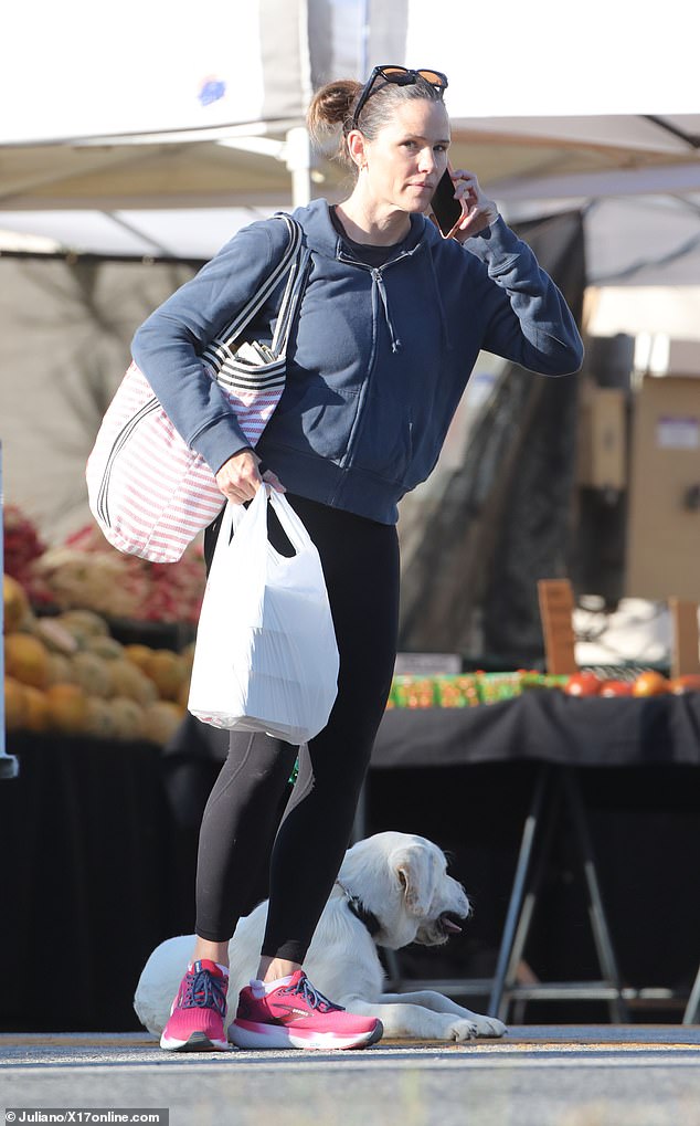 She wore dark designer sunglasses and sculpted magenta sneakers