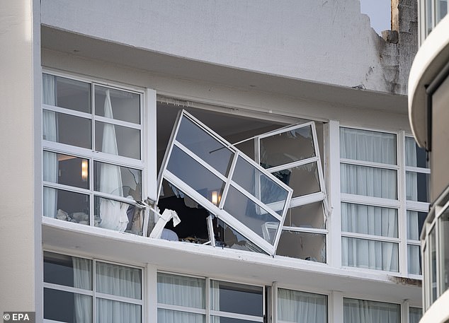 Two people who were taken to hospital with smoke inhalation when the plane hit their hotel room window (above) were 