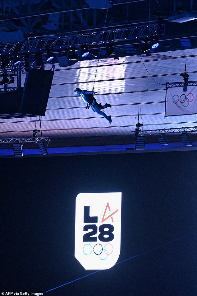 Actor Tom Cruise descends from the stadium roof as part of the Los Angeles 2028 (LA28) handover ceremony