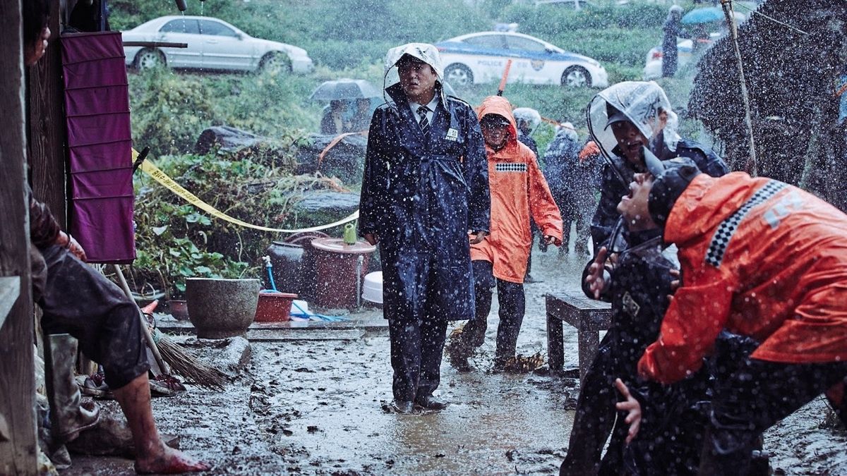 A rainy image from The Wailing, as detectives enter a crime scene