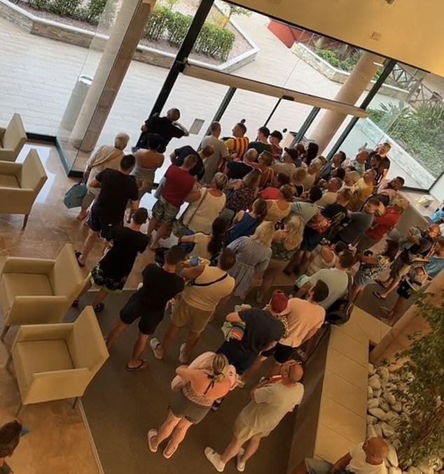 Armed with their towels in hand, newly released footage shows holidaymakers crowding the entrance to the pool, ready for the morning battle to grab the first sunbeds