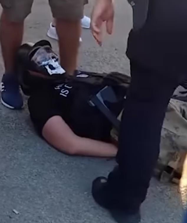 He was tackled to the ground by police and was seen lying on his back as officers stood above him