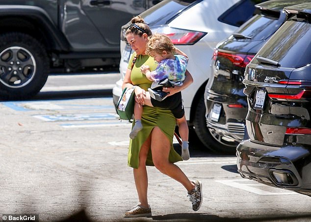 The 33-year-old pregnant reality star, dressed in a black tracksuit that highlighted her growing baby bump, carried her daughter Ocean, three, as they walked through a parking lot