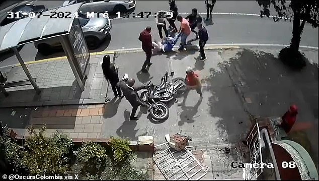 Bystanders took turns trying to vandalize a motorcycle while its driver, an alleged robber, was brutally beaten in Bogotá, Colombia, on July 31.