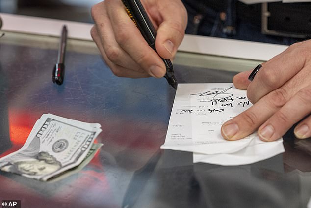 Republican vice presidential candidate Sen. J.D. Vance signs the check that reads 