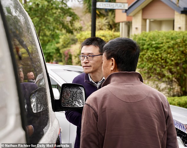 Professor Wang's colleagues are pictured talking to detectives at the crime scene on Wednesday