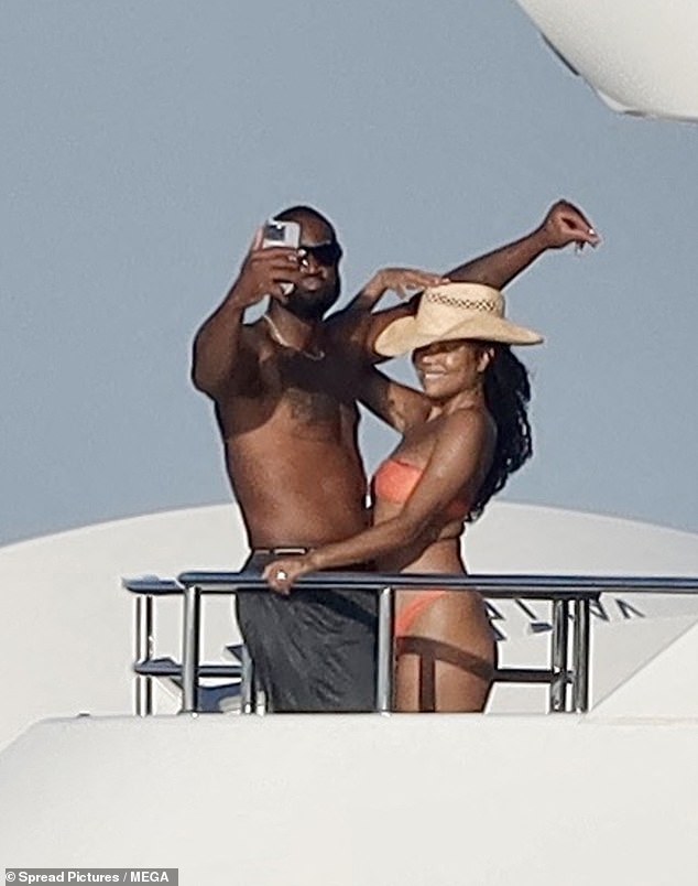 The American actress, 51, showed off her amazing figure in an orange bikini as she geared up for selfies with her retired NBA husband Dwyane Wade, 42