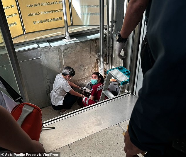 Doctors work at the foot of the elevator shaft in the departure hall of Suvarnabhumi International Airport in Bangkok