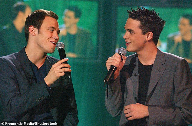 The star also revealed that he still tried to hide his sexuality later in his career (pictured with Gareth Gates in Pop Idol 2002)