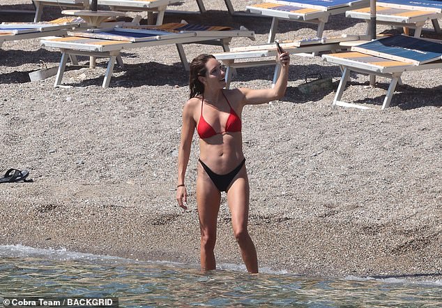 Kayla showed off her toned figure as she paddled in the ocean and appeared to be talking to someone on the phone