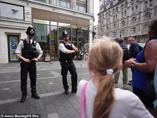 Police have not yet confirmed a motive for the attack but say it was not terror-related (pictured: police officers at the scene in Leicester Square in London)