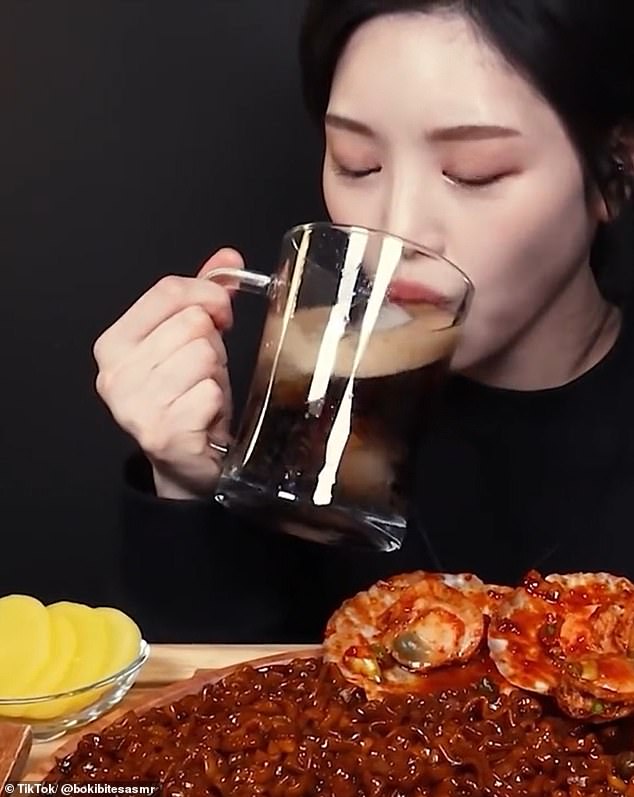 Boki slurps down a large pint of coke as she dishes up another large plate of food for her followers