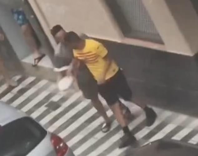 Earlier footage also showed Nasraoui (the yellow Barcelona shirt) being led away by a member of the community before police arrived