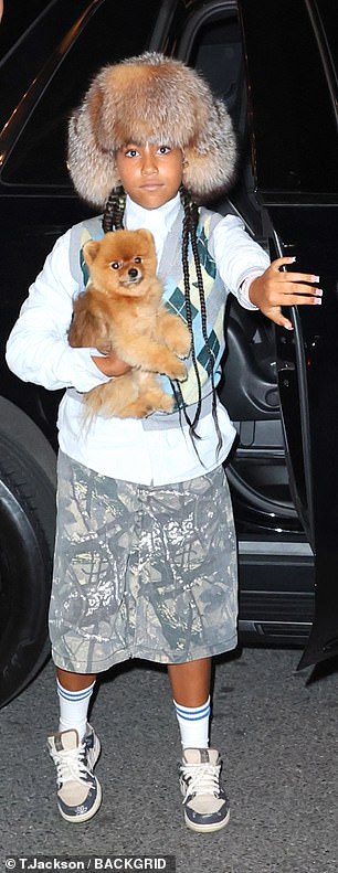 North, already a true fashionista, paired her striking headpiece with a blue button-down shirt, a gray and blue argyle cardigan and baggy camouflage shorts