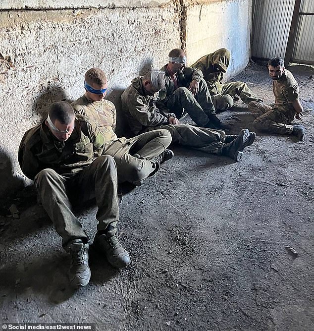 Several soldiers sat on the ground with blindfolds on after surrendering