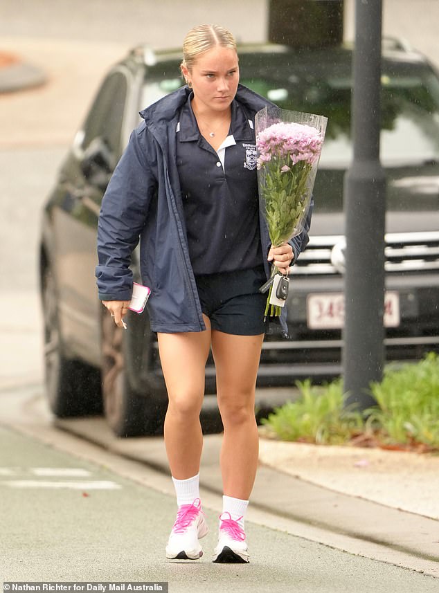 An Emanuel College staff member pays her respects Thursday after the little girl was allegedly murdered by her mother