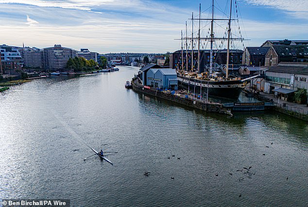 A rower passes the SS Great Britain at Bristol Harbourside in the early morning sun on Tuesday