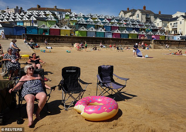 People relax on the beach during the warm weather in Walton-on-the-Naze in Essex on Tuesday