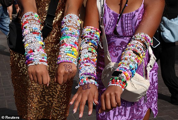 Fans show off their Taylor Swift bracelets before her concert, after the cancellation of three Taylor Swift concerts in Vienna due to a planned attack, outside Wembley Stadium in London, Britain, August 15, 2024. REUTERS/Mina Kim