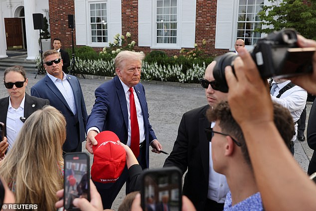 Trump signs hats and shakes hands after wrapping up his unconventional press conference