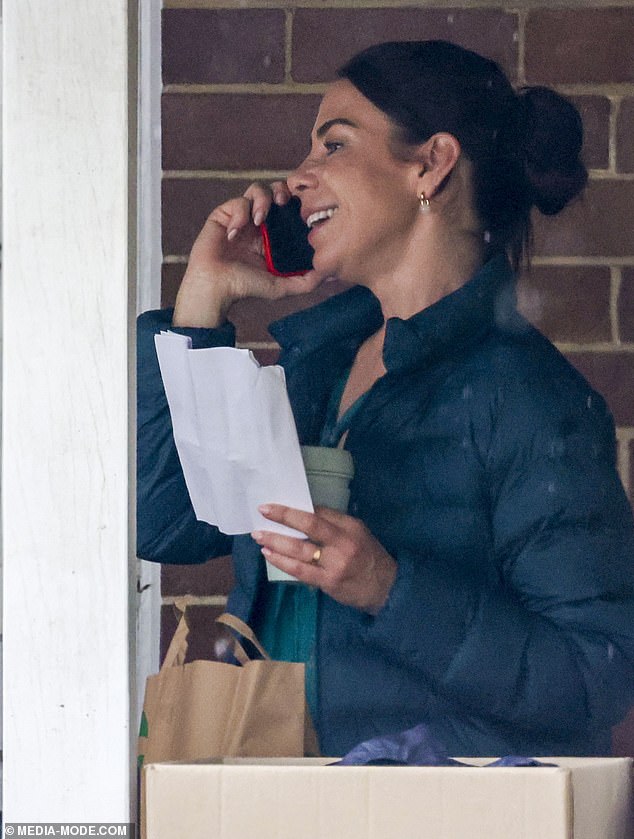 Kate wore a black puffer jacket and showed off a chunky gold ring on her left finger as she juggled a cup of coffee and a piece of paper