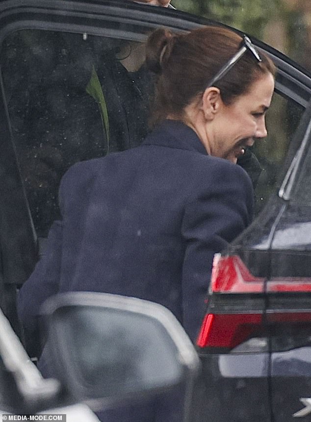 She paired the look with sneakers before braving the wet weather and sneaking away in a parked vehicle nearby