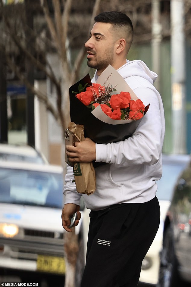 The 33-year-old celebrity trainer looked dejected as he made his way into the $2,200-a-night hotel in Sydney's posh Double Bay suburb, carrying a bouquet of roses and a wrapped bottle of booze.